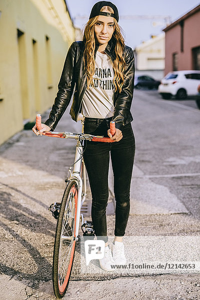 Porträt einer modischen jungen Frau mit Fahrrad