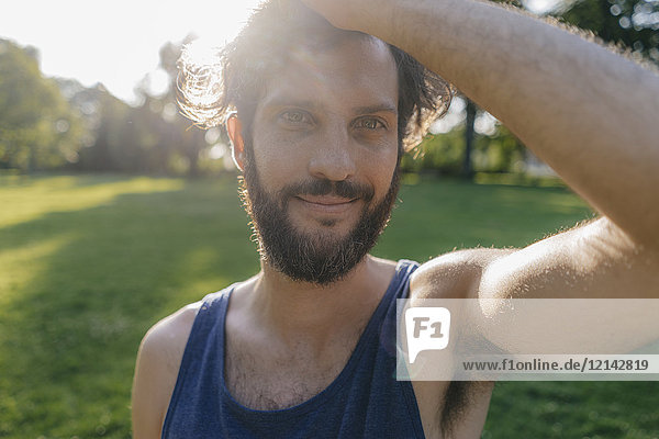 Portrait of smiling man with beard at sunset in a park