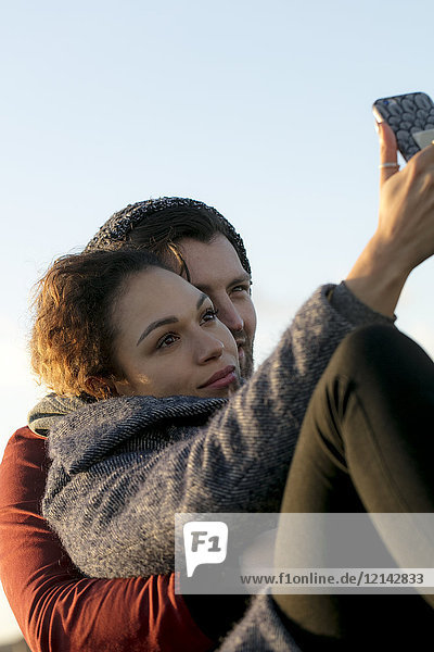 Junges Paar mit Selfie im Freien