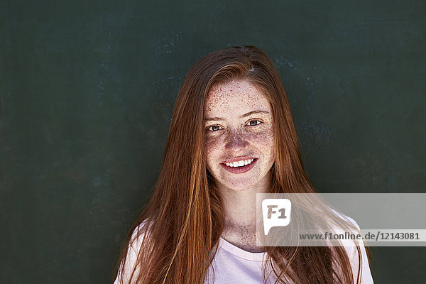 Porträt einer lächelnden jungen Frau mit Sommersprossen
