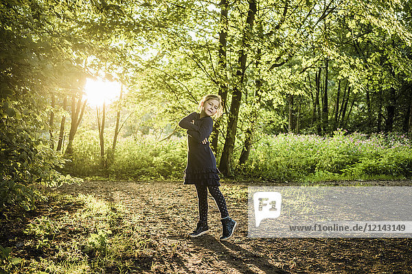 Confident girl standing on forest path