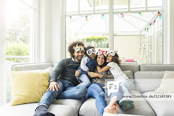 Happy family sitting on couch  wearing animal masks