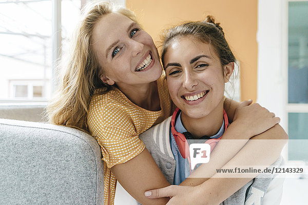 Porträt von zwei glücklichen jungen Frauen  die sich umarmen