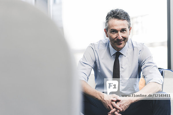 Portrait of smiling businessman sitting in lounge