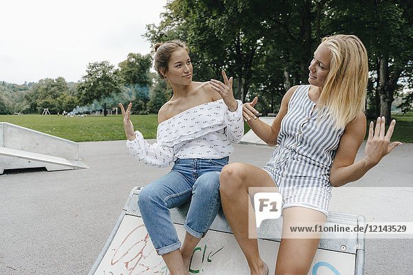 Zwei glückliche junge Frauen im Skatepark