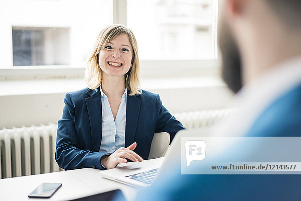Businesswoman smiling at businessman in office