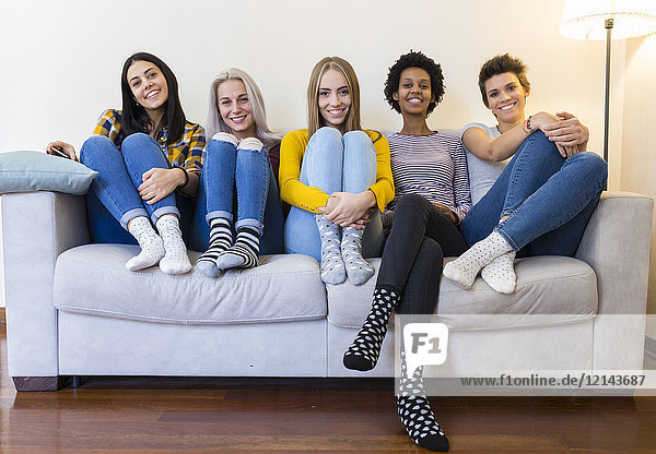 Portrait of group of female friends sitting on sofa in living room