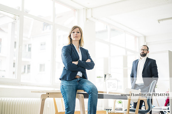 Portrait of confident businesswoman and man in office