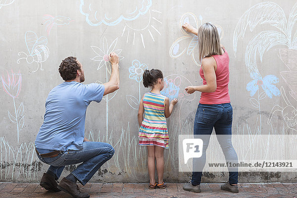 Familienzeichnung bunte Bilder mit Kreide auf einer Betonwand