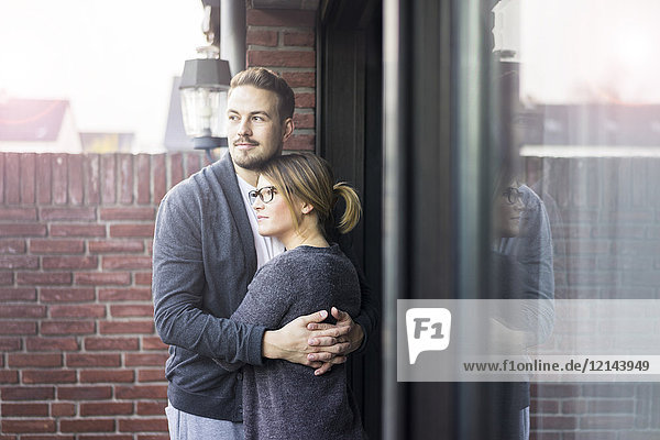 Paar auf der Terrasse zu Hause umarmend