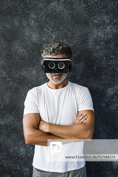 Mature man looking through VR glasses backwards