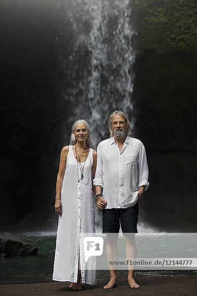 Liebevolles Seniorenpaar vor dem tropischen Wasserfall