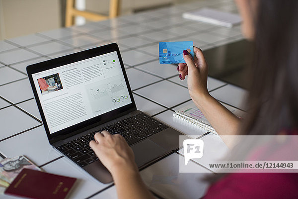 Junge Frau mit Laptop  Bezahlung mit Kreditkarte