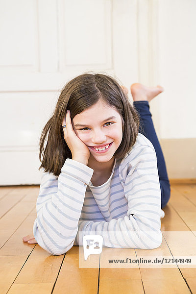 Porträt des lachenden Mädchens auf dem Boden liegend