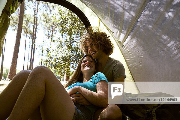 Glückliches junges Paar  das sich in einem Zelt umarmt.