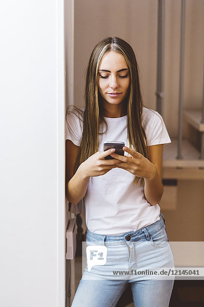 Young woman at home using cell phone