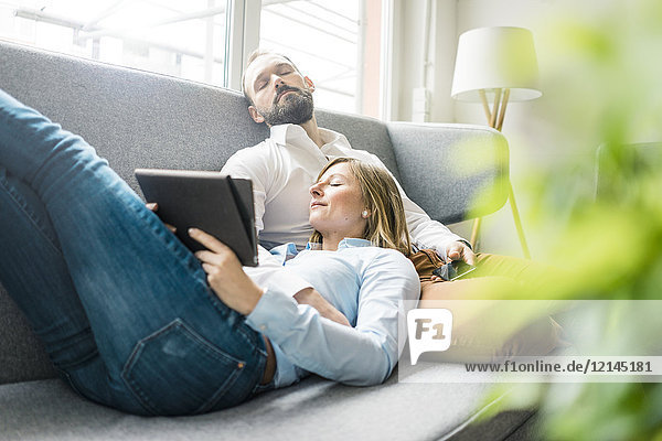 Paar Entspannung auf der Couch mit Tablett und Handy