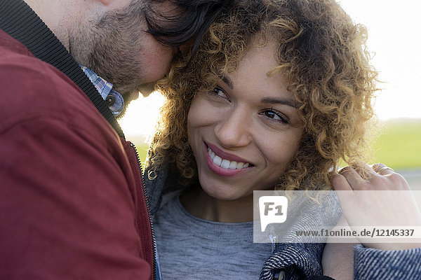 Portrait of smiling young couple close together outdoors