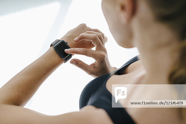 Close-up of woman in sportswear adjusting her smartwatch