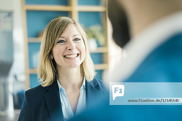 Businesswoman smiling at businessman in office