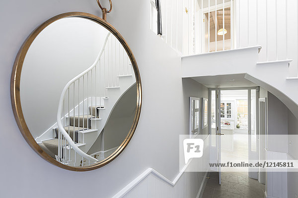 Reflection of foyer staircase in round mirror