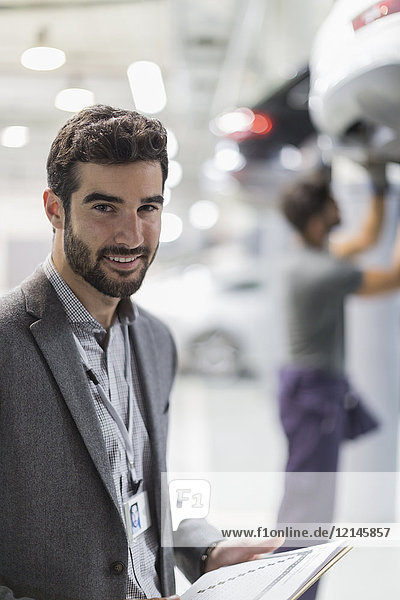 Portrait lächelnder  selbstbewusster Mann in der Autowerkstatt