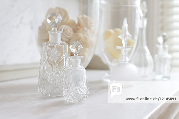 Kristall-Parfümflaschen auf weißer  luxuriöser Marmortheke