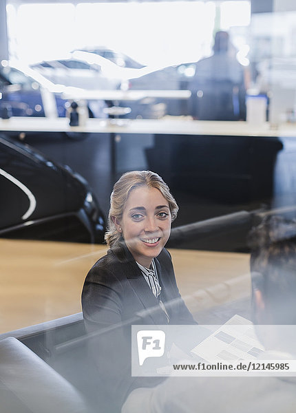 Portrait lächelnde Autoverkäuferin im Autohaus-Showroom