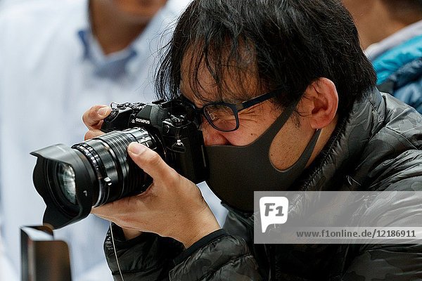 March 3  2018  Yokohama  Japan - A man tries out an Olympus camera at the CP+ Camera & Photo Imaging Show 2018 in Pacifico Yokohama. Japan's largest camera and photo imaging exhibition bring together 1 123 exhibitor booths during the four-day trade show at the Pacifico Yokohama and OSANBASHI Hall. Organizers expect approximately 70 000 visitors until March 4th.