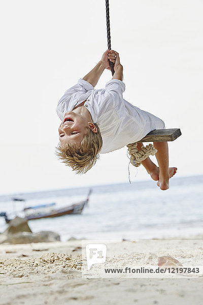 Thailand  Phi Phi Phi Inseln  Ko Phi Phi Phi  glücklicher Junge auf einer Seilschaukel am Strand