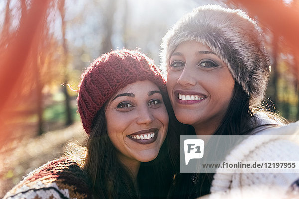 Selfie von zwei glücklichen hübschen Frauen in einem herbstlichen Wald