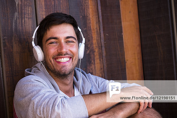 Portrait of happy young man wearing headphones