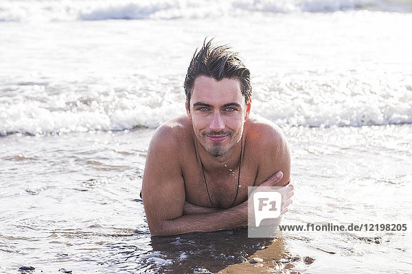 Portrait of smiling young man bathing in the sea