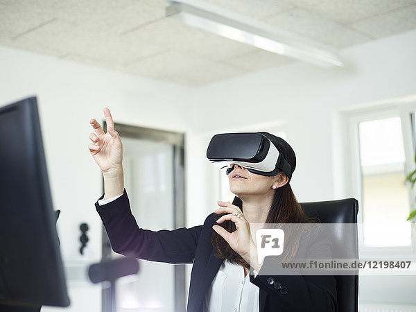 Businesswoman wearing VR glasses in office