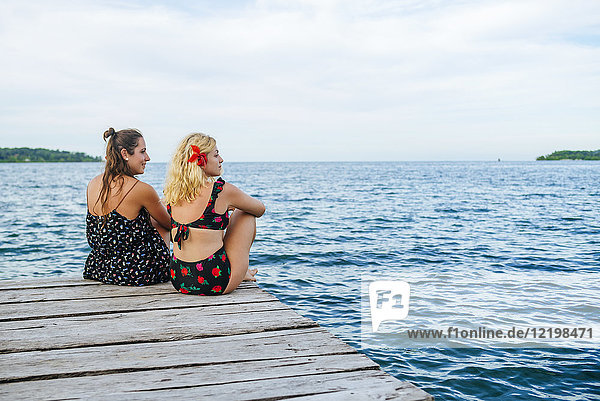 Panama  Bocas del Toro  Two women sitting on wooden jetty