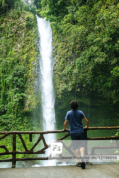 Costa Rica  Vulkan Arenal Nationalpark  Mann mit Blick auf den Wasserfall von La Fortuna