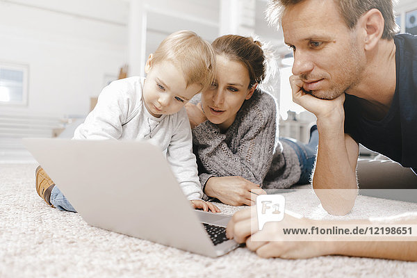 Family using laptop on the floor