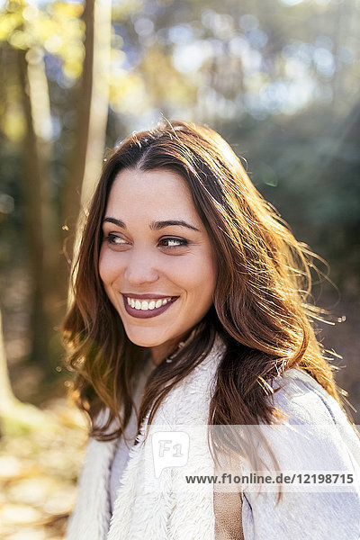 Porträt einer schönen lächelnden Frau im Herbstwald