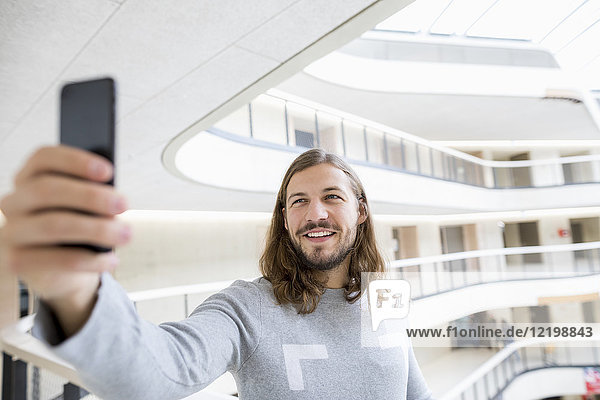 Portrait od smiling man taking selfie with cell phone
