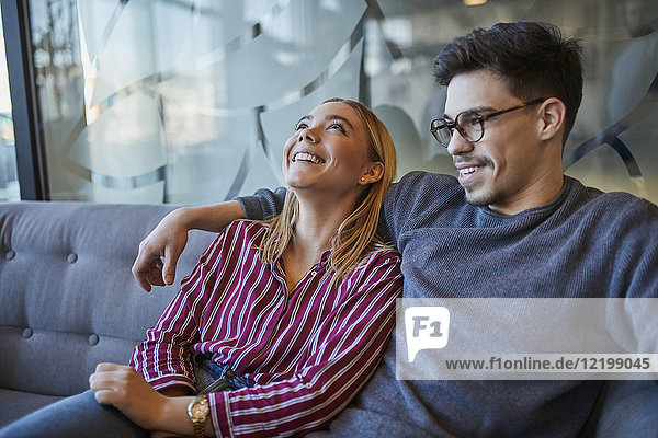 Happy relaxed couple sitting on sofa in a cafe