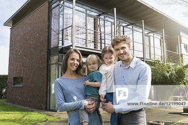 Portrait of smiling family in front of their home