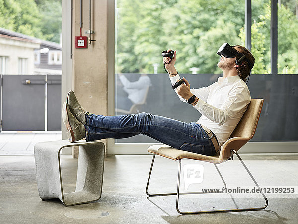 Mann mit VR-Brille auf Stuhl sitzend