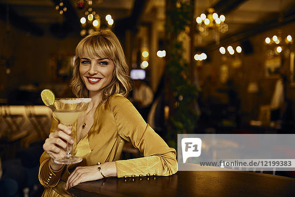 Porträt einer eleganten Frau mit Cocktail in einer Bar
