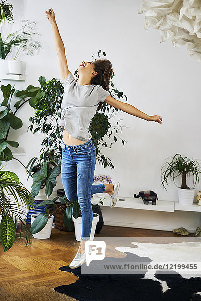 Exuberant young woman jumping in a room