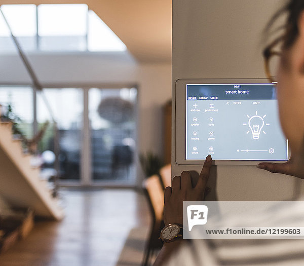 Woman using screen with smart home control functions at home
