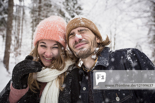 Happy couple having fun with snow in winter landscape