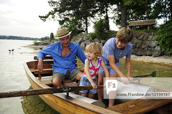 Deutschland  Bayern  Murnau  Großvater mit Enkel und Enkelin im Ruderboot