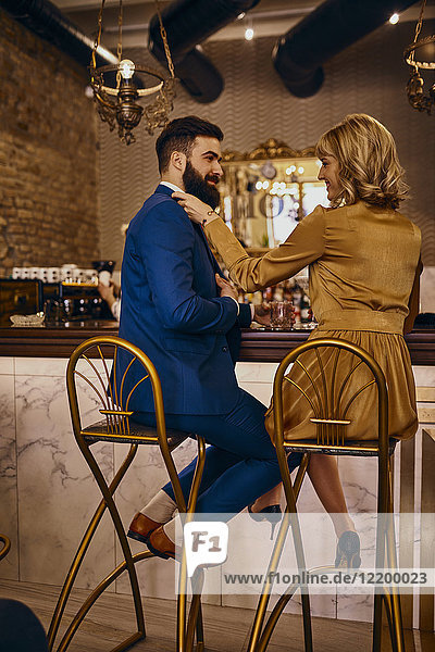 Elegant couple sitting at the counter in a bar