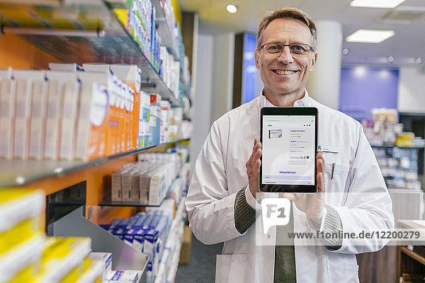 Portrait of smiling pharmacist in pharmacy holding tablet with digital order