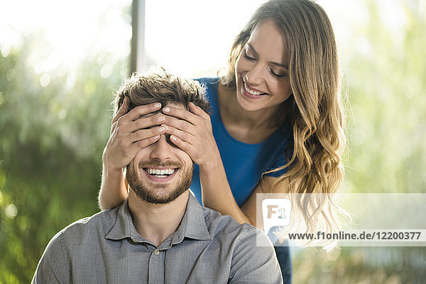 Smiling woman covering her boyfriend's eyes